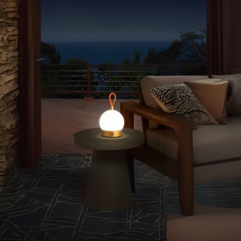 Cozy evening setup with a glowing portable orb lamp on a side table beside a modern armchair – styled by The Niomi