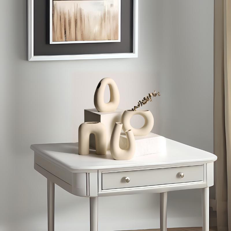Set of modern abstract ceramic vases in neutral tones on a minimalist white table – curated by The Niomi